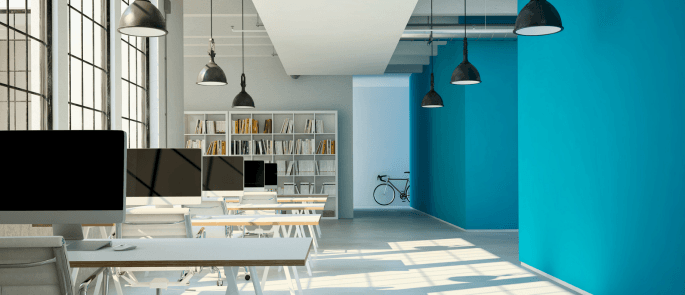 an office space with five desks and a bookcase