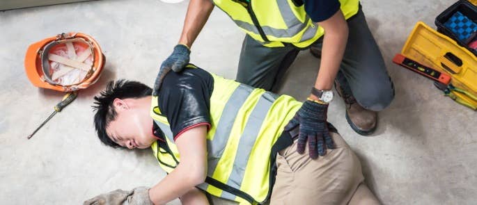 Worker assisting collapsed colleague