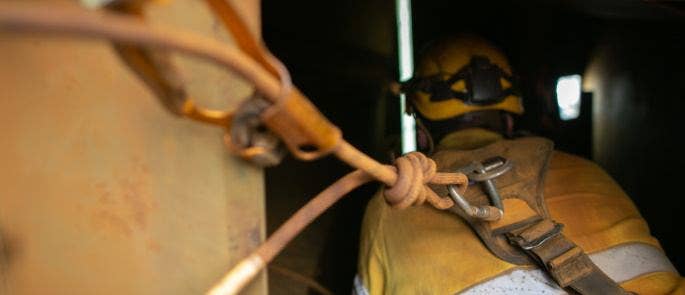 Worker with harness entering confined space