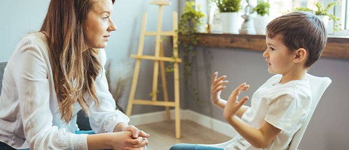 A teacher having a conversation with a young child in her class