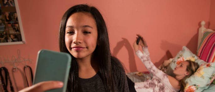 Two teenage girls using Snapchat