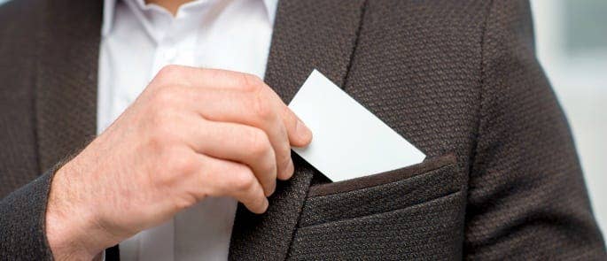 A man putting a business card in his jacket pocket