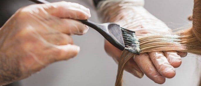 A hairdressing using gloves to reduce occupational hazards such as contact dermatitis