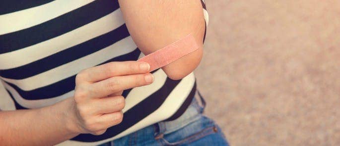 A person putting a plaster on their elbow