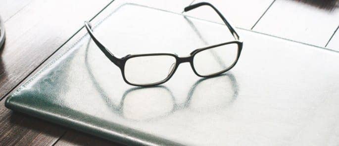 A pair of glasses resting on a desk
