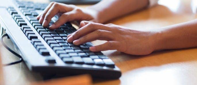 Employee typing on keyboard with correctly supported wrists and arms