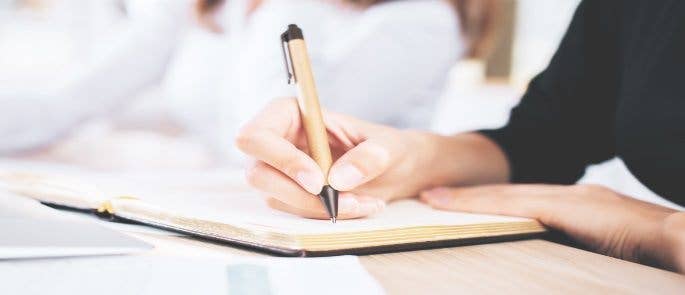 Person writing notes in a book