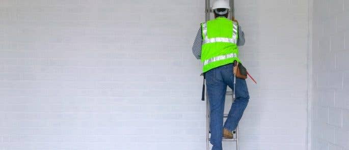 Man in protective clothing climbing a ladder