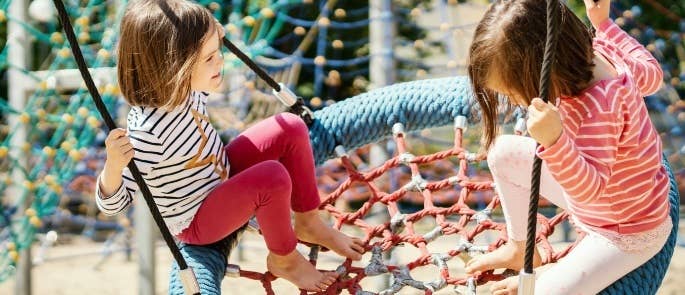 Girls playing on a swing in the park