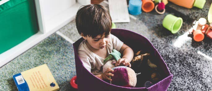 Toddler playing with toys in basket