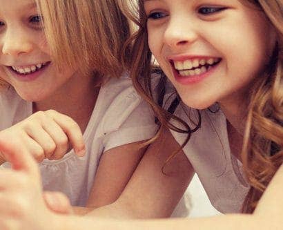 two girls playing on electronic tablet