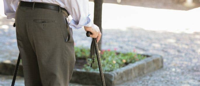 elderly man using walking sticks