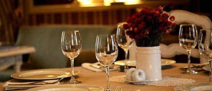 A table set with wine glasses and flowers