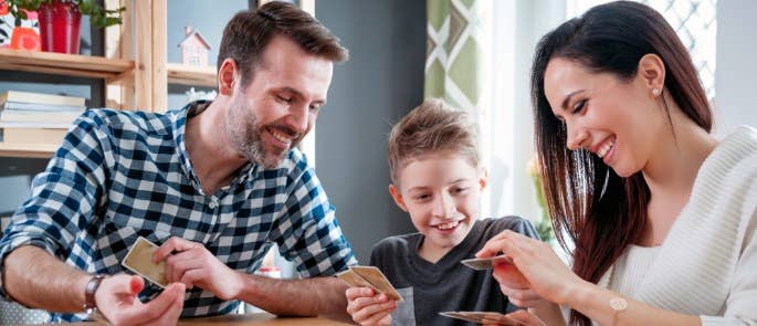 Family playing a board game with cards