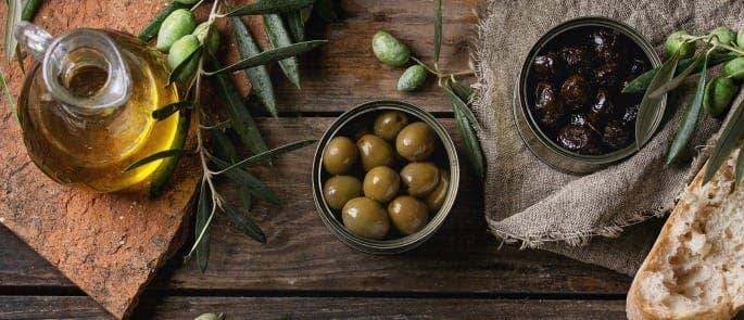 can of olives open with olive oil on the table