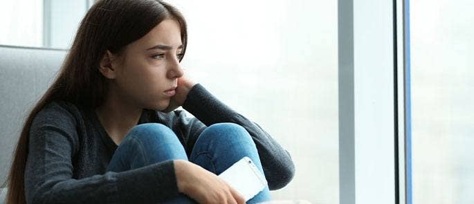 Young girl sat looking out of the window