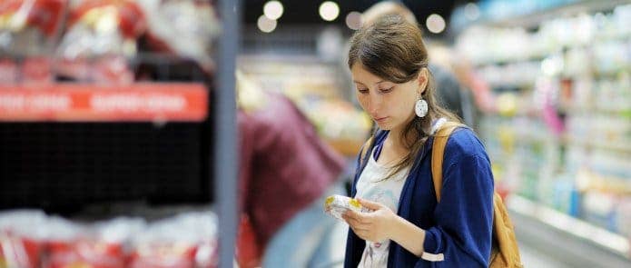 A woman checking the nutrition label on cheese