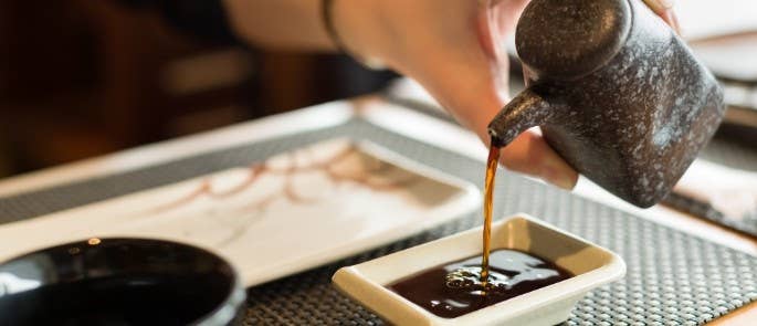 Woman pouring soy sauce at a restaurant