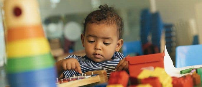 Young child playing with early years toys