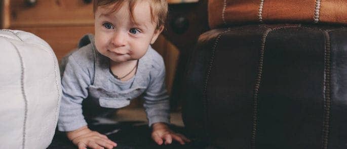 Child crawling between Moroccan poufs