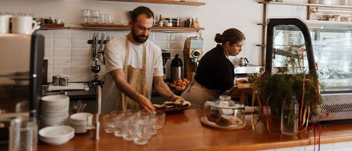 Cafe workers cleaning work surfaces
