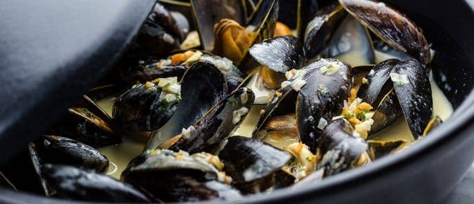 A pot of soup with mussels