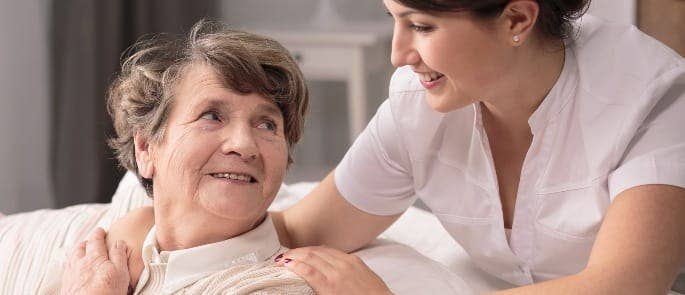 A nurse ensuring her patient is content with their care