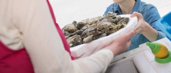 Waitress passing shellfish to diner