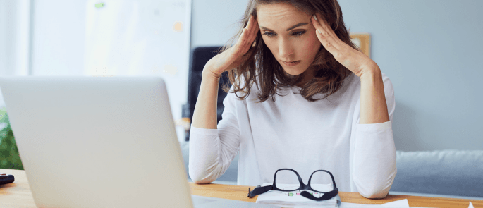 woman with her head in her hands at a computer