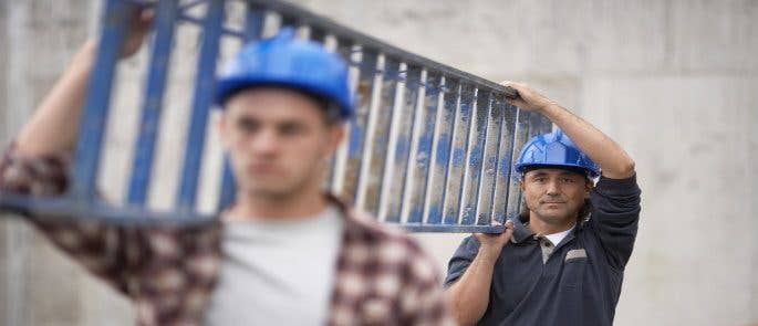 Two men carrying a ladder safely