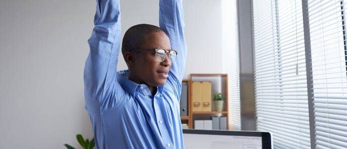 Worker stretching at his desk