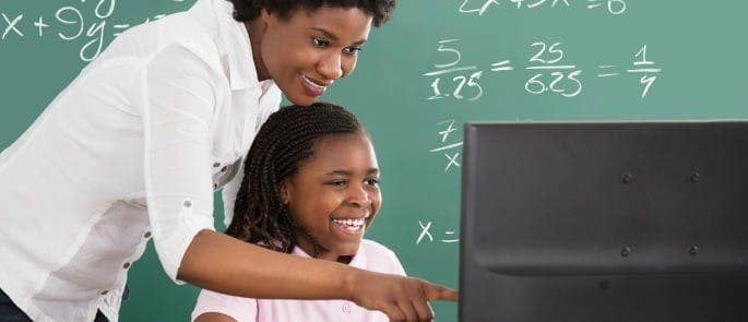 Teacher and pupil on computer