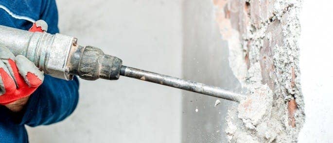 Worker using a hand-held concrete grinder