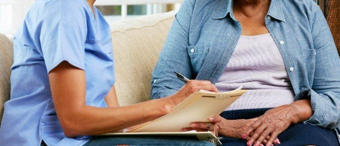 Carer speaking to a patient and taking notes