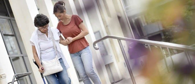 betreuer hilft einer älteren Dame bei der Evakuierung während eines Feueralarms