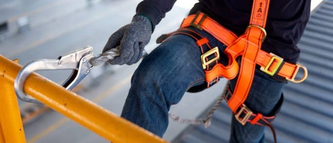 Construction worker using safety harness and safety line on construction site