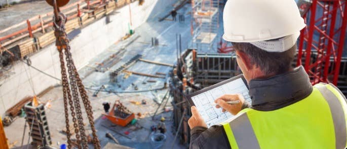 Employer writing notes construction site