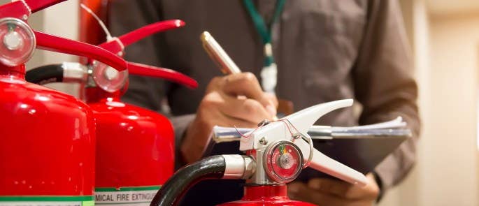 Worker inspecting extinguishers