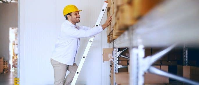 Man climbing a ladder in a stockroom