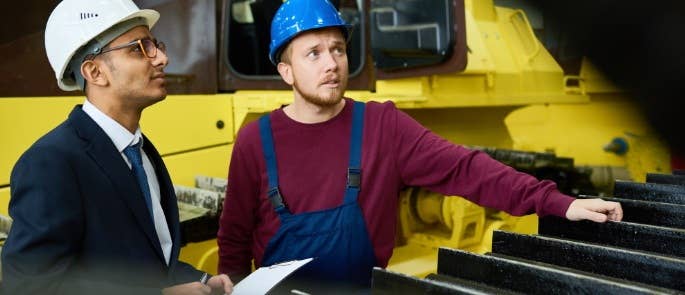 Supervisor and worker inspecting equipment