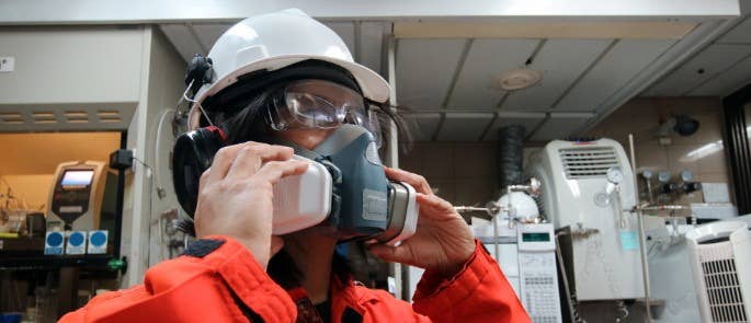 Worker putting on respiratory protective equipment PPE