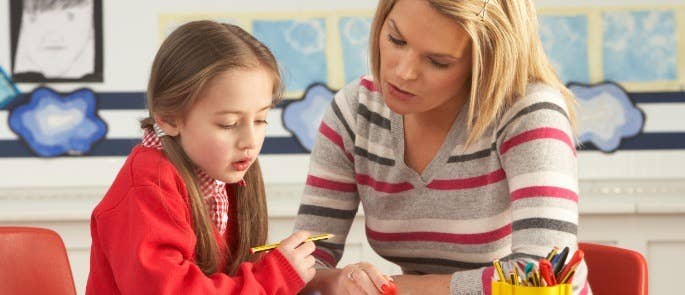 L'enseignant aide l'élève à travailler en classe