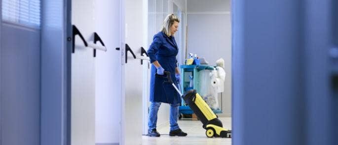 Person cleaning the floor using a machine