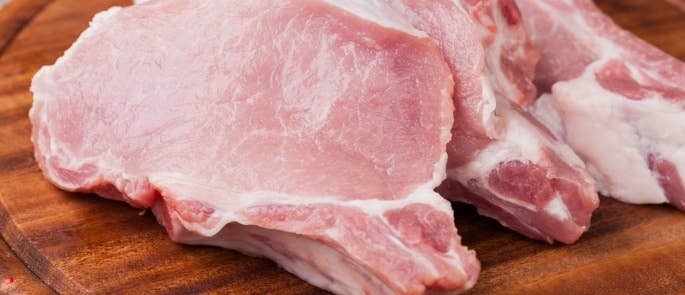 Raw pork chops on a cutting board