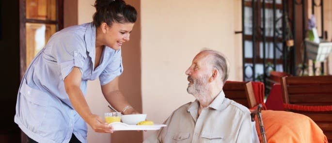 health care staff member offering meal to a patient, increasing their positive relationship