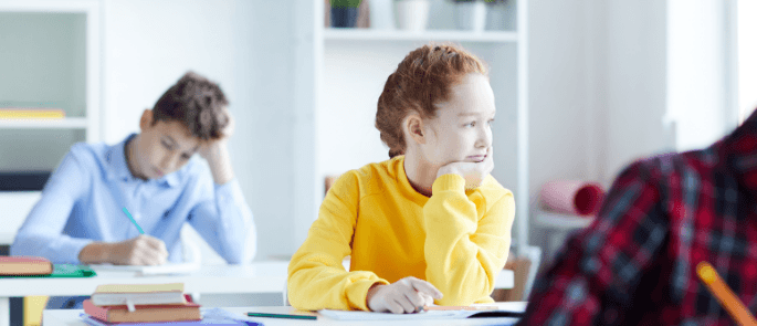 Girl in school daydreams out of window