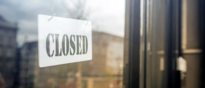 A closed sign hanging in a restaurant door window