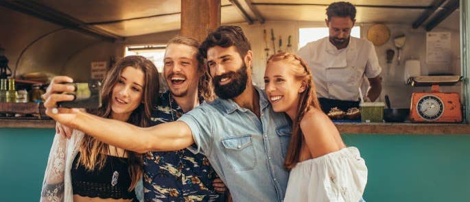 group taking selfie in front of festival food stall