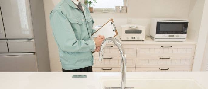 A man carrying out an EHO home kitchen inspection