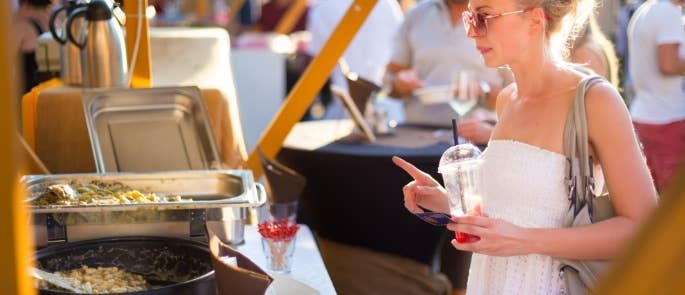 A woman buying food from a food stall at a festival